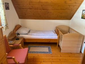 多内尔斯巴赫瓦尔德Ferienhaus Bettina Rassis Feriendorf Donnersbachwald的小房间设有一张床和一把椅子