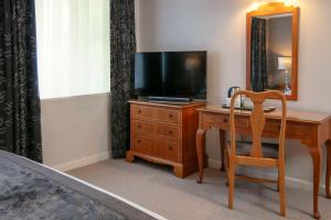 梅尔顿莫布雷西松拜诺尔贝斯特韦斯特酒店的一间卧室配有一张桌子、一台电视和一把椅子
