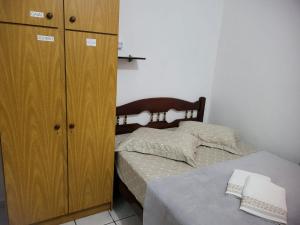 波梅罗迪Espaço Wunder Platz的一间卧室配有一张床和一个木制橱柜