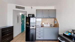 弗吉尼亚海滩SureStay Studio by Best Western Virginia Beach Oceanfront的厨房配有不锈钢冰箱和白色橱柜
