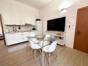San Giorgio di PianoLa Casa di Leo Apartments的厨房配有玻璃桌和白色橱柜