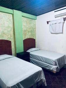 拉塞瓦Los Guacamayos La Ceiba的一间客房内配有两张床的房间