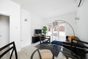 泰晤士河畔金斯顿2BR 2Baths ground floor garden apartment的客厅配有玻璃桌和镜子