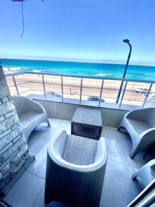 亚历山大Alexandria Luxury Apartments Sporting Direct Sea View的一个带椅子的阳台,享有海滩美景