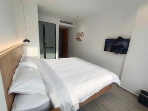 黄山风景区黄山望峰楼的一间卧室配有两张带白色床单的床