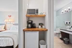 托菲诺Tofino Motel Harborview的酒店客房带一张床和一台微波炉