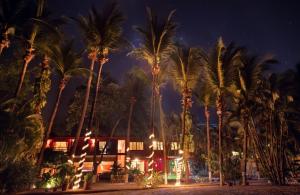 塔马林多Hotel Laguna del Cocodrilo的一群棕榈树在一座建筑前