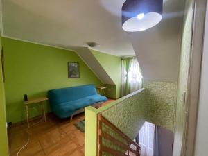 塔尔卡Casa Talca的客厅设有蓝色的沙发和绿色的墙壁。