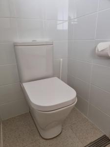 波高尔宾Elfin Hill Vineyard Accommodation的白色瓷砖浴室内的白色卫生间