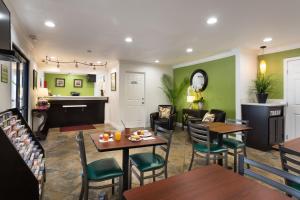圣何塞Rodeway Inn San Jose HWY-101 Tully Rd Exit的餐厅拥有绿色的墙壁和桌椅