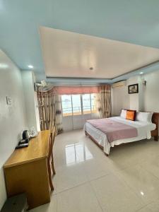 吉婆岛New Way Hotel的一间卧室配有一张床、一张书桌和一个窗户。