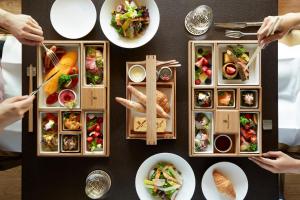 日光The Ritz-Carlton, Nikko的一张餐桌,上面放满了食物,人们在吃饭