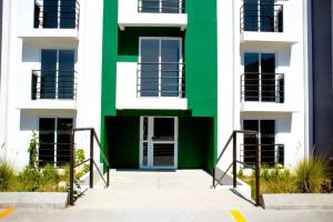 危地马拉Apartamento e109的拥有绿色和白色外墙的建筑