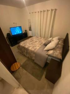 危地马拉Apartamento e109的一间卧室配有一张床、一张沙发和一台电视