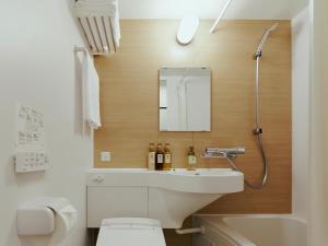 泉佐野R Hotel Kansai Airport的一间带水槽、卫生间和镜子的浴室