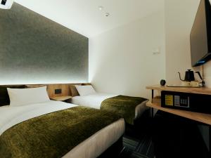 泉佐野R Hotel Kansai Airport的酒店客房设有两张床和电视。