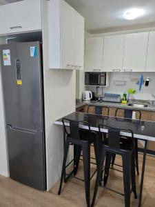 塔尔卡瓦诺Departamento Brisa del sol的厨房配有黑桌和冰箱。