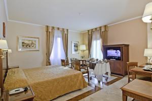 罗马Tmark Hotel Vaticano的酒店客房 - 带一张床和用餐室