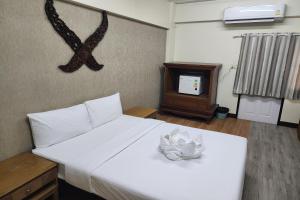 Ban Bang ProngKim Hotel At Bangplong的卧室配有白色的床和电视
