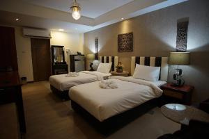Ban Bang ProngKim Hotel At Bangplong的酒店客房,配有两张带白色床单的床