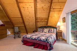 塔霍马The Lazy Bear Lodge的一间卧室设有一张床和木制天花板