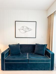 拜伦湾拜伦湾波浪酒店的客厅里一张蓝色的沙发,墙上挂着画
