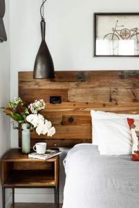 吉朗Timber Door Luxury Accommodation Geelong的一张带木制床头板的床和一张带鲜花的桌子