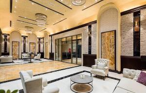 阿吉曼CMA Skyline Sanctuary Apartments - Ajman Corniche UAE的大厅,带椅子和桌子的建筑