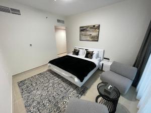 阿吉曼CMA Skyline Sanctuary Apartments - Ajman Corniche UAE的一间卧室配有一张床、一张沙发和一把椅子