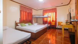 大雅台Lauriens Hotel Tagaytay的一间卧室配有两张双层床和电视