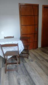 乌鲁瓜亚纳Casa confortável!的一间卧室配有一张床、两把椅子和一扇门