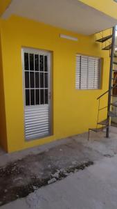 乌鲁瓜亚纳Casa confortável!的黄色的建筑,有门和梯子