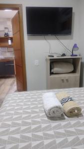 乌鲁瓜亚纳Casa confortável!的卧室配有一张壁挂式平面电视的床。