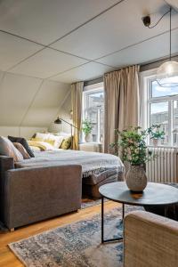 雷克雅未克Venture Vacations-Cultural Gem in the Heart of Central Reykjavík的一间卧室配有一张床、一张沙发和一张桌子