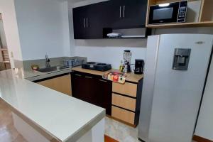 伊皮亚莱斯Hermoso Apartamento en Ipiales的厨房配有白色冰箱和微波炉