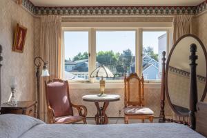 太平洋丛林马丁旅馆的一间卧室配有一张床、两把椅子和一个窗户