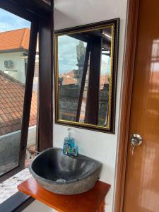 塞米亚克Rodin Bali Hostel的一间带石制水槽和镜子的浴室