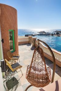 卡尔帕索斯La Scala Luxury Villa Μikis Theodorakis with jacuzzi的阳台配有椅子,享有水景