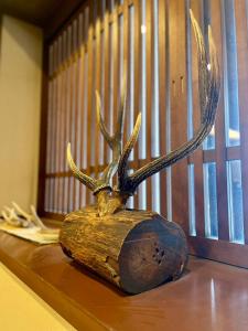 奈良萨若萨瓦吉吉田屋酒店的鹿头雕像,桌子上有鹿角