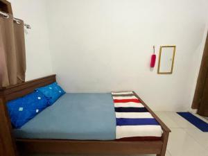 NgadipuroOYO 93784 Kost Bu Eli Syariah的小卧室配有一张带蓝色床罩的床