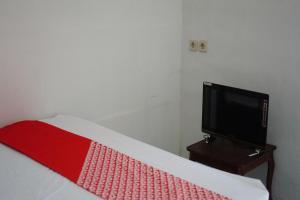 NgadipuroOYO 93784 Kost Bu Eli Syariah的一间卧室配有一张床和一张桌子上的电视