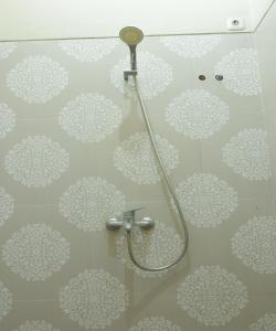 NgadipuroOYO 93784 Kost Bu Eli Syariah的浴室的墙壁上装饰有白色的鲜花,设有淋浴。