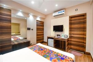 加尔各答FabHotel Prime Jalsa的一间酒店客房,设有两张床和电视