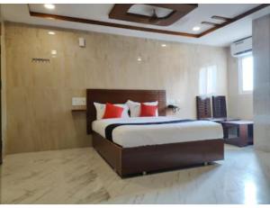 瓦朗加尔Hotel Grand Inn, Warangal的一间卧室配有一张带红色枕头的大床