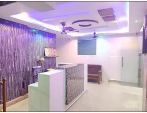 瓦朗加尔Hotel Grand Inn, Warangal的客房设有电视和紫色灯天花板。
