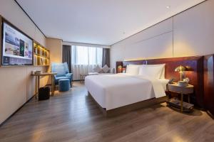 海口海口国贸中心亚朵X酒店的卧室配有一张白色大床和一张书桌