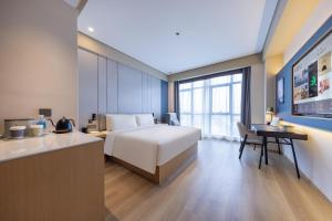 Jiangning南京江宁未来网络小镇亚朵X酒店的酒店客房配有一张床、一张书桌和一间厨房。