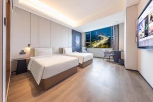 广州广州大道南琶洲会展中心亚朵X酒店的酒店客房设有两张床和一台平面电视。