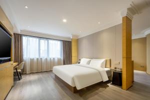 无锡无锡三阳广场中山路亚朵X酒店的卧室配有一张白色大床和电视。