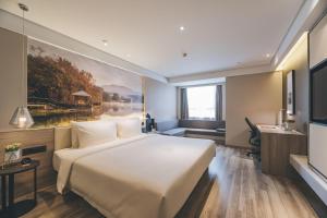 南京南京南站亚朵酒店的酒店客房设有一张大床和一张书桌。